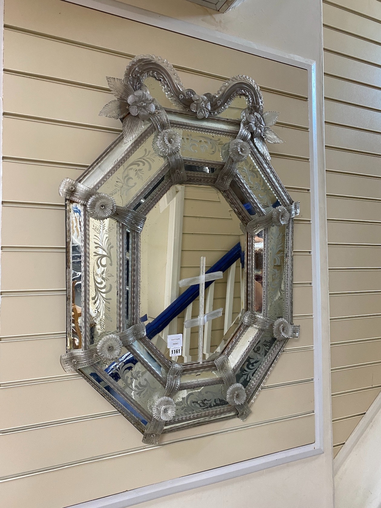 A Venetian octagonal engraved wall mirror with floral scroll pediment and bevelled central plate, width 68cm, height 91cm.